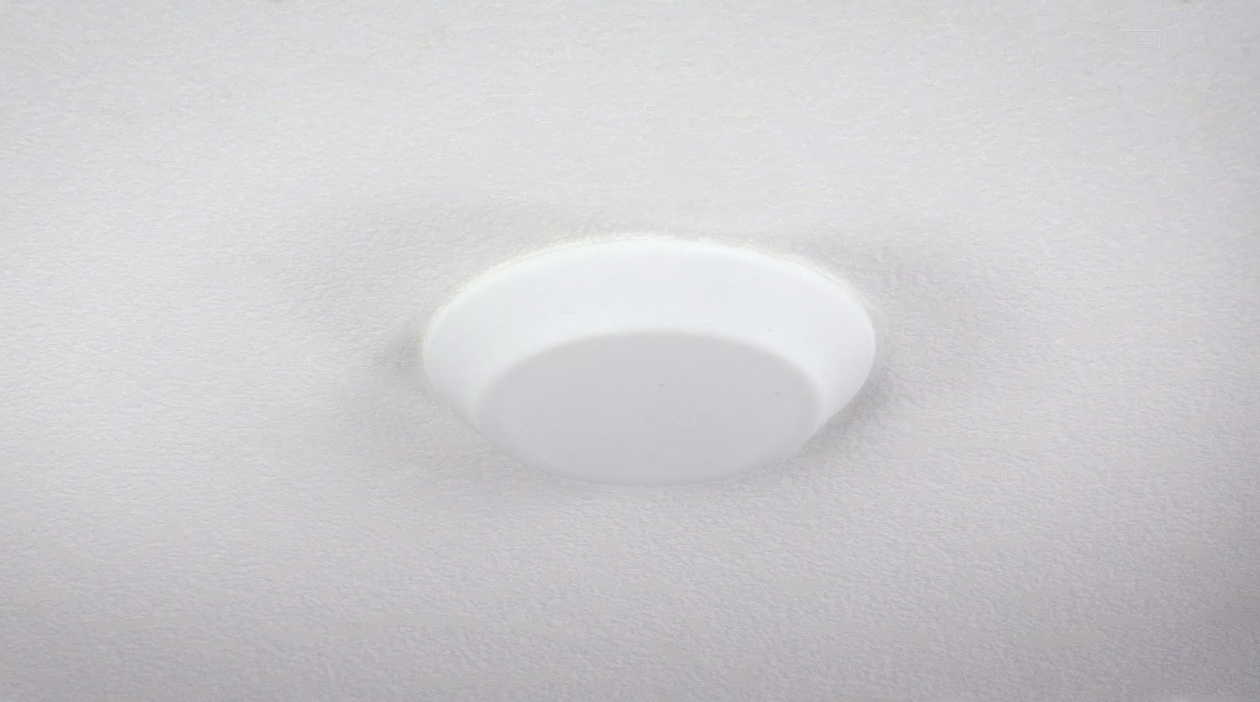 white AtlasIED’s SHS strategically hidden speaker cover installed in a ceiling